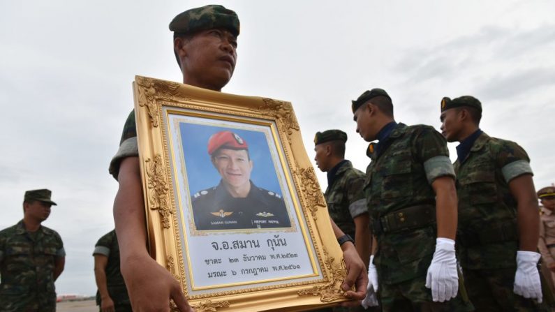 Un soldat de la Marine royale thaïlandaise porte un portrait de Saman Gunan, qui est mort par accident dans la grotte de Tham Luang lors d'une mission de sauvetage pour sauver les 12 garçons et leur entraîneur. Les officiels ont averti que la fenêtre d'opportunité pour libérer les jeunes est "limitée". Photo PANUMAS SANGUANWONG / AFP / Getty Images.