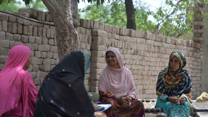 Cette photo prise le 7 juillet 2018, dans le village pakistanais Nazeeran Mai, une femme de 60 ans, n'a jamais voté aux élections législatives précédentes, elle s'entretient avec des voisins du village de Mohri Pur. Les hommes ont interdit aux femmes de voter dans le village de Mohri Pur aux alentours de 1947. Photo AAMIR QURESHI / AFP / Getty Images.