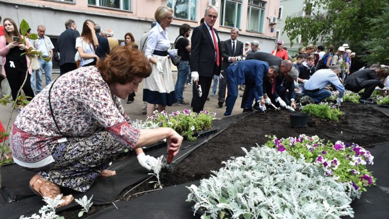  Les gens plantent des fleurs en assistant à la cérémonie d'ouverture d'un jardin public à la mémoire de Anna Politkovskaïa, journaliste russe anti-Kremlin, tuée dans son immeuble en octobre 2006. Photo VASILY MAXIMOV/AFP/Getty Images.