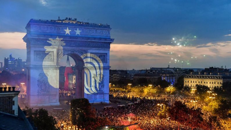 Cette photo prise depuis la terrasse de laPublicis le 15 juillet 2018 montre une projection du logo de l'équipe nationale française de football avec deux étoiles sur l'emblématique Arc de Triomphe de Paris alors que les gens se rassemblent pour célébrer la victoire de la France en Russie. (GERARD JULIEN/AFP/Getty Images)