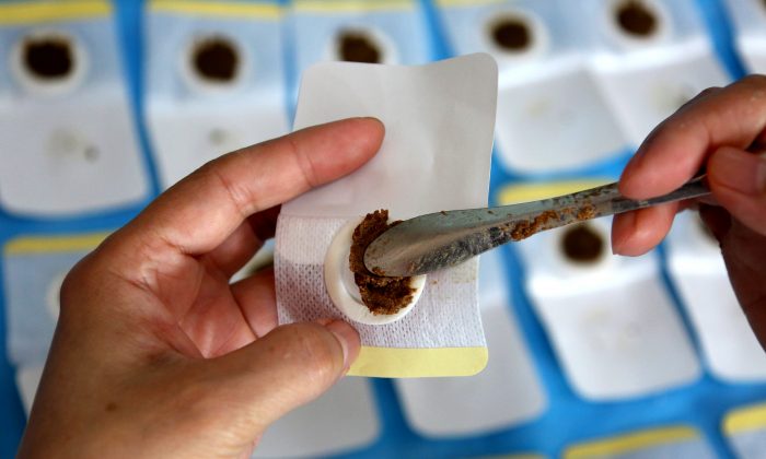 Un médecin prépare des pansements thérapeutiques remplis de plantes médicinales dans un hôpital de médecine traditionnelle chinoise à Zaozhuang City, province du Shandong, Chine, le 17 juillet 2018. (VCG)
