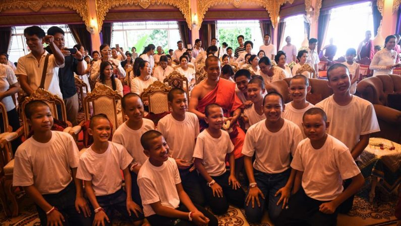 Le 4 -août 2018. L'entraîneur thaïlandais Ekkapol Chantawong et les 12 membres de l'équipe de football des "Sangliers sauvages"' posent ensemble pour une photo après une cérémonie marquant la fin de la retraite au temple Wat Phra That Doi Tung. Photo: LILLIAN SUWANRUMPHA / AFP / Getty Images.
