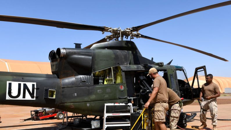 Des soldats canadiens de la mission du maintien de la paix des Nations Unies au Mali travaillent sur un hélicoptère au camp Castors à Gao le 4 août 2018. Les forces armées canadiennes ont officiellement lancé leur mission de maintien de la paix dans le nord du Mali le 31 juillet. Photo SEYLLOU/AFP/Getty Images.