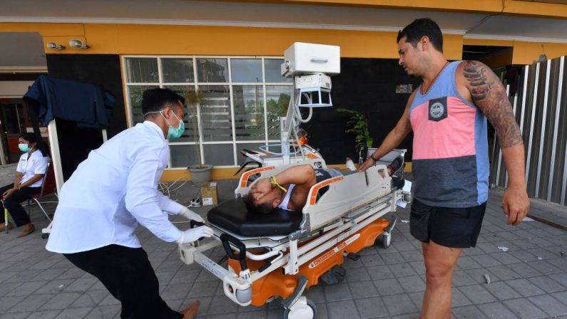 Le 6 août 2018. Un touriste étranger blessé reçoit des soins médicaux dans une unité de fortune installée à l'extérieur de l'hôpital de Ruslan à Mataram, sur l'île indonésienne de Lombok. Photo ADEK BERRY / AFP / Getty Images.