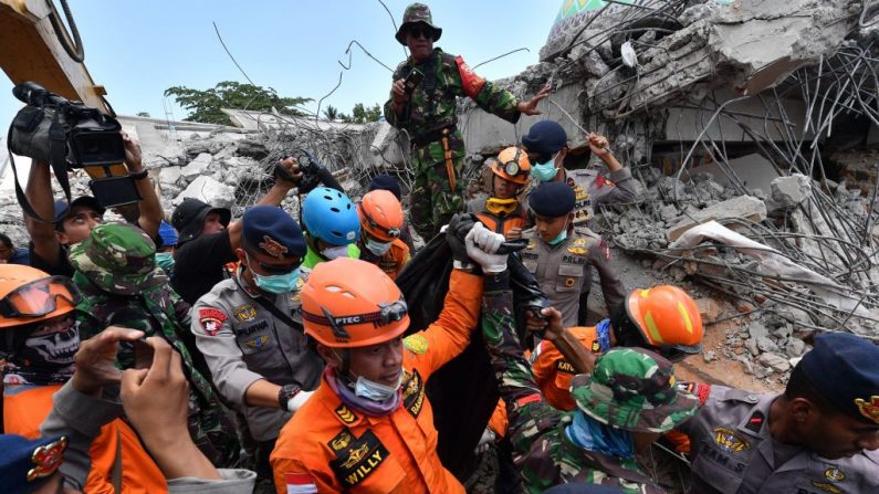 Les membres d'une équipe de recherche et de sauvetage transportent le corps d'une victime du séisme à Bangsal, au nord de Lombok, le 8 août 2018. Photo ADEK BERRY / AFP / Getty Images.