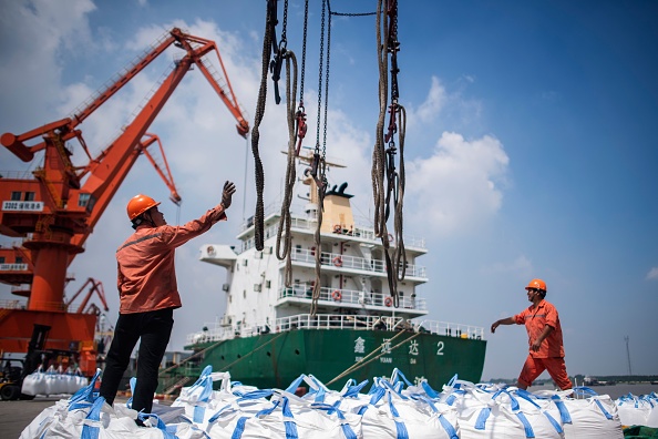 Le déchargement des sacs de produits chimiques dans un port de Zhangjiagang, dans la province du Jiangsu, dans l’Est de la Chine, le 7 août 2018 (JOHANNES EISELE/AFP/Getty Images)