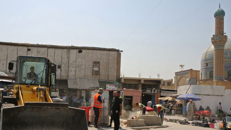 Des ouvriers irakiens retirent les blocs de ciment des T-Walls dans une rue de Bagdad le 5 août 2018. Plus de 1 000 rues et ruelles ont été rouvertes à Bagdad depuis l'année dernière et 305 points de contrôle ont été enlevés. Photo SABAH ARAR / AFP / Getty Images.