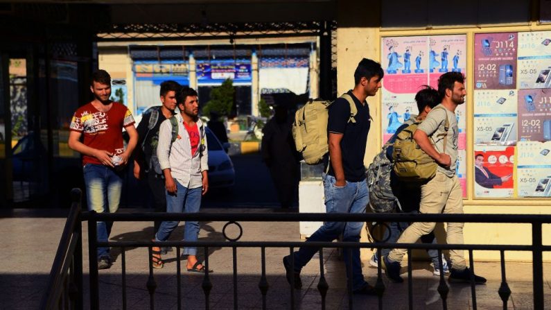 Le 4 août 2018. Des rapatriés afghans d'Iran portent leur sac à dos alors qu'ils arrivent dans la province afghane d’Hérat. Un nombre record de 442 344 Afghans sont rentrés volontairement ou ont été expulsés d’Iran cette année après les sanctions imminentes des États-Unis. Photo HOSHANG HASHIMI / AFP / Getty Images.