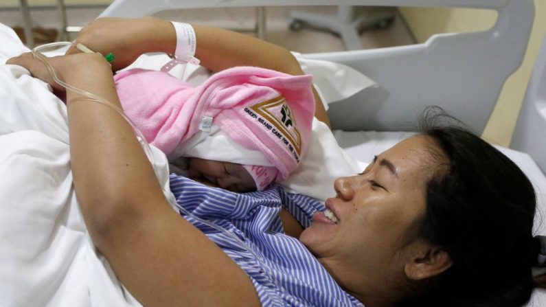 Le 10 août 2018, Pan Ei Mon, l'épouse du journaliste Wa Lone, détenu par Reuters, embrasse sa petite fille nouveau-née Thet Htar Angel dans sa chambre d'hôpital à Yangon. Photo ANN WANG / AFP / Getty Images.