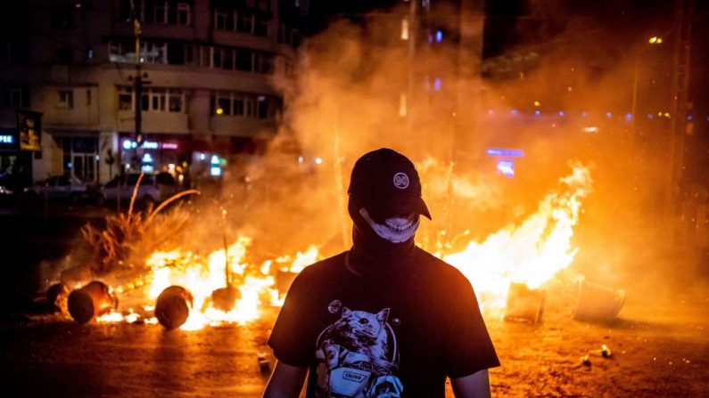 Un manifestant passe devant un incendie lors d'affrontements avec la police lors d'une manifestation contre le gouvernement devant le siège du gouvernement roumain, à Bucarest, le 10 août 2018. Photo : ANDREI PUNGOVSCHI / AFP / Getty Images.