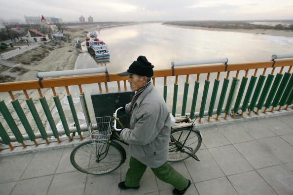 HARBIN, CHINE : Un résident traverse un pont sur la rivière Songhua dans la ville de Harbin, au nord de la Chine. Photo PETER PARKS / AFP / Getty Images.