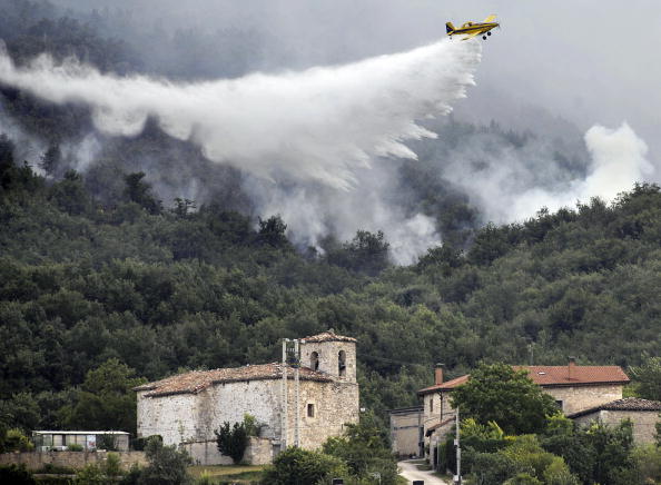 Un avion a largué de l'eau sur un feu de forêt dans le nord de l'Espagne, la circulation sur une autoroute reliant les deux pays, la France et l’Espagne a été interrompue durant plusieurs heures frappés par la canicule. Photo : RAFA RIVAS / AFP / Getty Images.