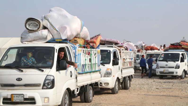 Des Irakiens déplacés, à cause de batailles contre le groupe État islamique montent dans des véhicules le 16 janvier 2018 alors qu'ils quittent un camp à l'ouest de Kirkouk pour retourner dans leur ville natale après avoir été repris par les forces irakiennes. Photo MARWAN IBRAHIM / AFP / Getty Images.