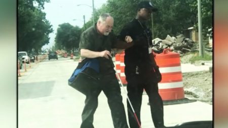 Les voitures s’arrêtent pour un aveugle de 69 ans, qui est escorté par son chauffeur de bus attentionné