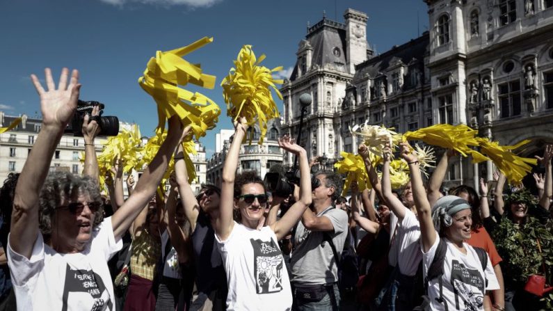 Des gens secouent des pompons jaunes et chantent des slogans alors qu’ils se rassemblent à la place de l’hôtel, à Paris, pour participer à la marche pour le climat, le 8 septembre 2018. Photo PHILIPPE LOPEZ / AFP / Getty Images.