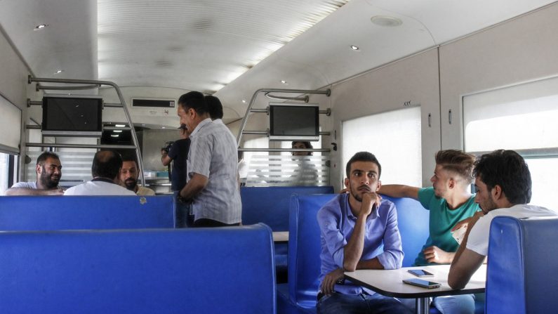 Les passagers irakiens sont assis dans une cabine du train dans la capitale Bagdad reliant la ville de Falloujah, à environ 70 kilomètres à l'ouest, le 19 août 2018. Il traverse les paysages de l'ouest de l'Irak par des cimetières automobiles chars calcinés et bâtiments effondrés. Photo SABAH ARAR / AFP / Getty Images.