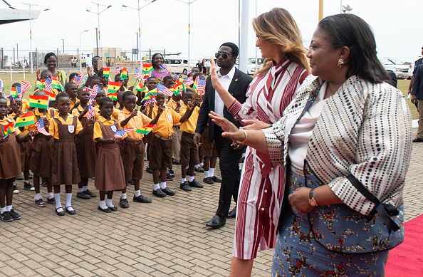 -La première dame des États-Unis, Melania Trump, et Rebecca Akufo-Addo, la première dame du Ghana, saluent les enfants lors d’une cérémonie d’arrivée à l’aéroport international de Kotoka, à Accra, le 2 octobre 2018. Photo : SAUL LOEB / AFP / Getty Images.