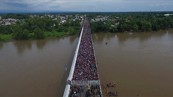 Vue aérienne d'une caravane de migrants honduriens se dirigeant vers les États-Unis, alors qu'elle est arrêtée à une barrière frontalière sur le pont international Guatemala-Mexique à Ciudad Hidalgo, dans l'État du Chiapas, au Mexique, le 19 octobre 2018.  (Photo : PEDRO PARDO/AFP/Getty Images)