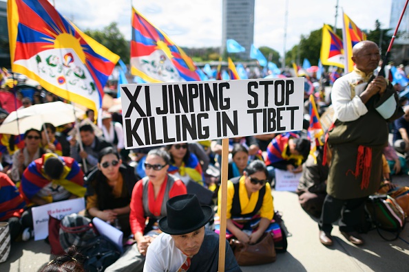 Un manifestant tient une pancarte indiquant « Xi Jinping cesse de tuer au Tibet » lors d'un rassemblement des communautés tibétaine et ouïghoures en Europe devant le bureau des Nations Unies à Genève le 16 septembre 2016. Plus de 400 personnes participent à la manifestation. Photo FABRICE COFFRINI / AFP / Getty Images.