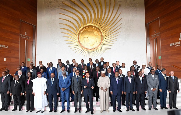 -Le président de l'Union africaine et président du Rwanda, Paul Kagame, le Premier ministre éthiopien Abiy Ahmed et le président de la Commission de l'Union africaine, Moussa Faki posent pour une photo avec les chefs d'Etat et de gouvernement. Le 17 novembre 2018. Photo MONIRUL BHUIYAN / AFP / Getty Images.