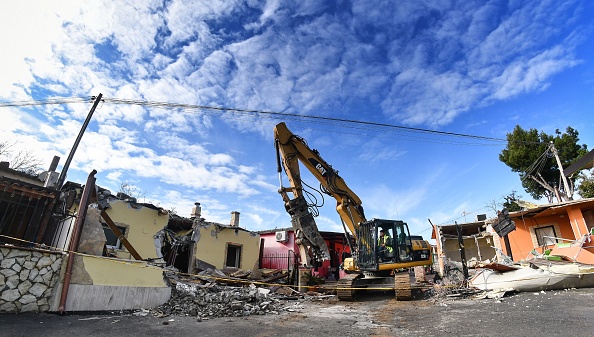-Un bulldozer démolit huit villas construites illégalement, saisies par la police de Rome dans le clan de la mafia de Casamonica, dans le district de Quadraro, dans le sud-est de la banlieue de Rome, le 21 novembre 2018. Photo ALBERTO PIZZOLI / AFP / Getty Images.