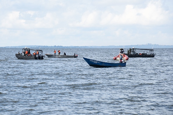 -Les pêcheurs locaux et le personnel de la marine ougandaise cherchent les passagers du bateau de croisière ayant chaviré sur le lac Victoria dans le village de Mutima, à environ 50 km au sud de la capitale Kampala. Le 25 novembre. Photo ISAAC KASAMANI / AFP / Getty Images.