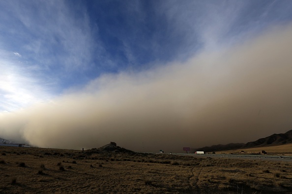 -Cette photo prise le 25 novembre 2018 montre une tempête de sable survenue à Zhangye dans la province du Gansu, au nord-ouest de la Chine. La tempête de sable a provoqué des incendies dans les zones rurales, elle a contraint la circulation à ralentir, incitant les habitants à se couvrir le visage. Photo by / AFP) / China OUT/Getty Images.
