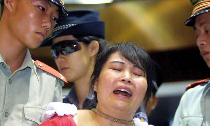 La trafiquante de drogue Wang Xiongyin s’effondrant alors qu'elle est condamnée à mort pour avoir vendu 200 grammes d'héroïne pour 27 000 yuans en 1999, à Guangzhou, le 26 juin 2003, alors que la Chine commémorait la Journée internationale de lutte contre la drogue. (Images STR / AFP / Getty)