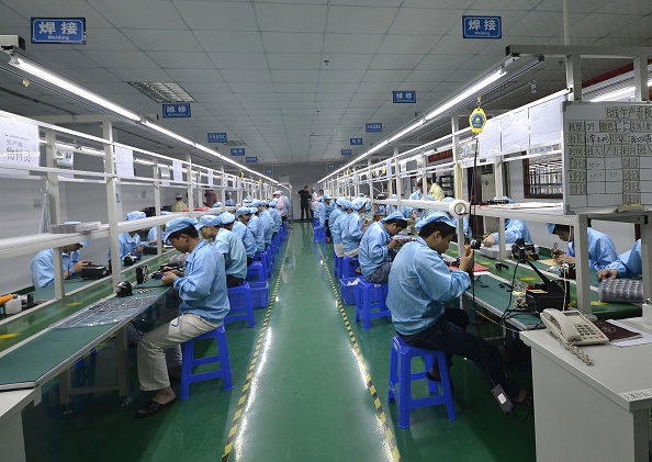-Des travailleurs chinois assemblent l'Apple Watch dans une usine produisant des milliers de pièces chaque jour à Shenzhen, en province du Guangdong dans le sud de la Chine. STR / AFP / Getty Images.