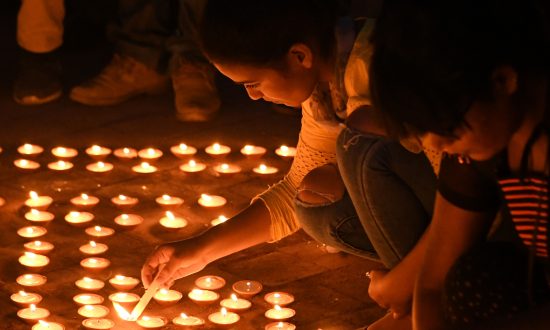 De jeunes Népalaises allument des bougies lors d'une veillée à la mémoire des victimes des attaques à l'acide à Katmandou le 27 septembre 2018. (Prakash Mathema/AFP/Getty Images)