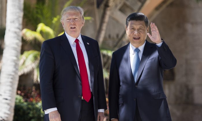Le dirigeant chinois Xi Jinping (à d.) salue la presse alors qu'il se promène avec le président américain Donald Trump dans le domaine Mar-a-Lago à West Palm Beach, en Floride, le 7 avril 2017. (Jim Watson/AFP/Getty Images)