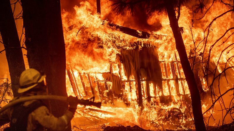 Le pompier Jose Corona évalue une résidence en feu durant l'incendie de Camp, à Magalia, Californie, vendredi 9 novembre 2018. (AP Photo/Noah Berger)