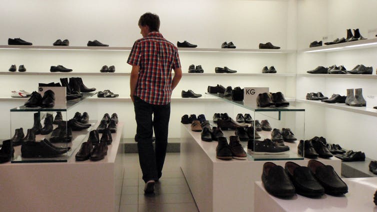 Un homme au rayon chaussures d’un grand magasin. Peut-il vraiment se permettre d’acheter une nouvelle paire ? (Alex Buirds/Wikimedia, CC BY-SA)
