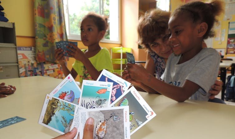 Atelier organisé en 2016 à Nouméa autour d’un jeu de cartes pour apprendre à connaître les récifs coralliens. (Catherine Sabinot/IRD, Author provided)