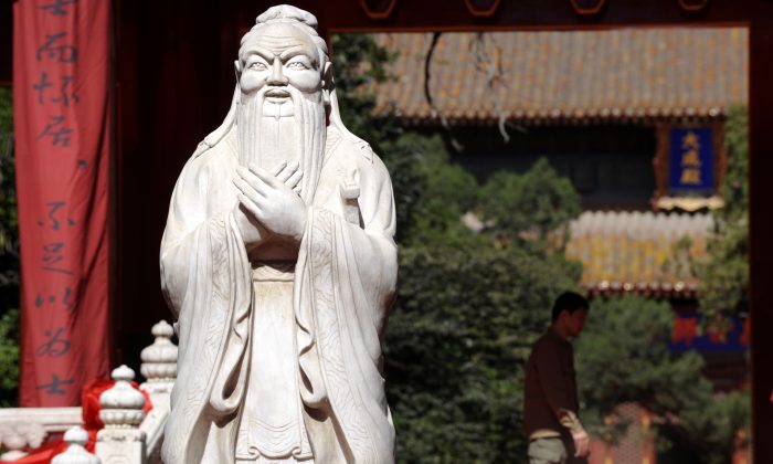 Un homme marche à côté de la statue de Confucius au Temple de Confucius à Pékin le 28 septembre 2010. (LIU JIN/AFP/Getty Images)