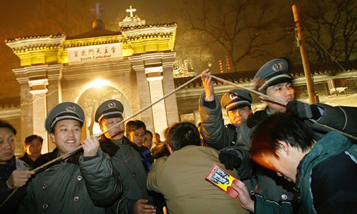 Des catholiques chinois franchissent un point de contrôle de sécurité devant une église catholique approuvée par le gouvernement à Pékin, le 24 décembre 2007, pour la messe de Noël. (©Getty Images | TEH ENG KOON/AFP)