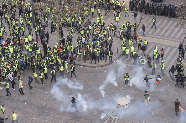 -Les manifestants portant des gilets jaunes (Gilets jaunes) se tiennent sur l'avenue des Champs-Élysées à Paris le 8 décembre 2018, lors d'une manifestation contre la hausse du coût de la vie, qu'ils imputent aux impôts élevés. Photo LUCAS BARIOULET / AFP / Getty Images.