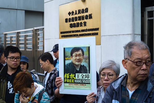 -Le 26 décembre 2018. Des militants tiennent une pancarte de l'avocat chinois des droits de l'homme en détention depuis 1.260 jours, un rassemblement devant le bureau de liaison chinois à Hong Kong, Wang Quanzhang, dont  le procès doit s'ouvrir en Chine. ANTHONY WALLACE / AFP / Getty Images.