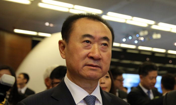 Wang Jianlin (au c.), PDG de Dalian Wanda Commercial Properties Co., assiste à l’introduction de sa société à la bourse de Hong Kong, le 23 décembre 2014. (Isaac Lawrence/AFP/Getty Images)