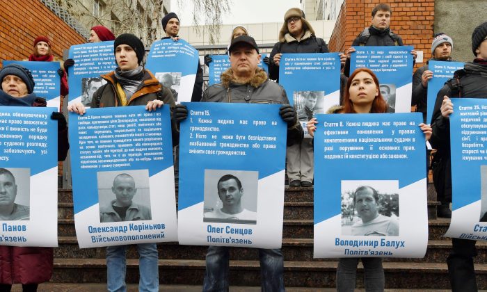 Des militants tiennent des photos de 70 prisonniers politiques ukrainiens emprisonnés en Russie (y compris les marins arrêtés à la suite du conflit de la mer d'Azov) lors d'une manifestation devant l'ambassade de l'UE à Kiev, le 11 décembre 2018. (SERGEI SUPINSKY/AFP/Getty Images)