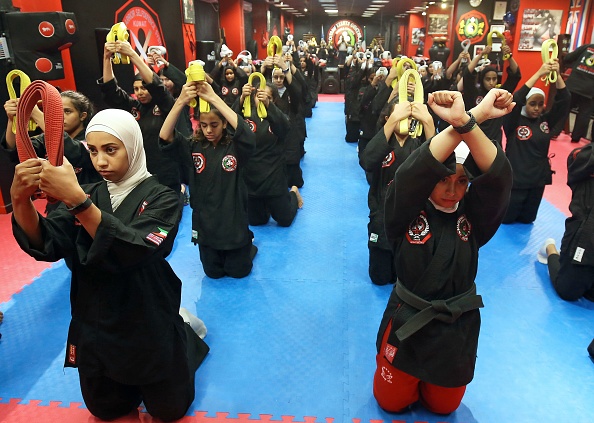-Les Koweïtiennes pratiquent l'art martial hybride Kajukenbo dans un club de la ville de Koweït le 22 octobre 2018. Le Kajukenbo est née à Hawaii dans les années 1940. Le nom du sport est dérivé des divers aspects des arts martiaux qui comprend : karaté, judo et jujitsu, kenpo et boxe. Photo de YASSER AL-ZAYYAT / AFP / Getty Images.