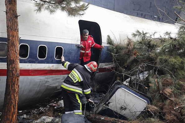 -Les pompiers et les forces de sécurité se retrouvent au milieu des débris d'un avion-cargo Boeing 707 qui aurait percuté un complexe résidentiel près de la capitale iranienne de Téhéran, avec 10 personnes à bord, le 14 janvier 2019. Photo de HASAN SHIRVANI / AFP / Getty Images.