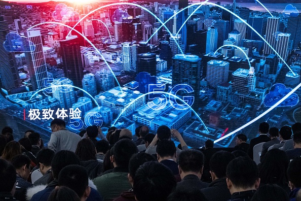 -Des journalistes et des invités regardent une bande-annonce lors d'une conférence de presse et du lancement des nouveaux produits 5G Huawei à Pékin le 24 janvier 2019. Photo FRED DUFOUR / AFP / Getty Images.