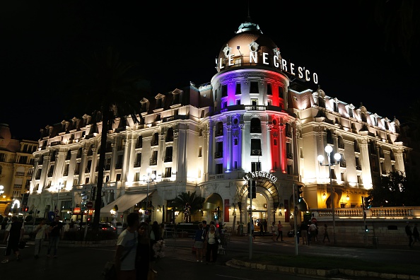-Cette photo prise le 17 juillet 2016 sur la Promenade des Anglais à Nice montre l’Hôtel Negresco illuminé aux couleurs du drapeau français en hommage aux victimes de l’attentat du 14 juillet. Photo VALERY HACHE / AFP / Getty Images.