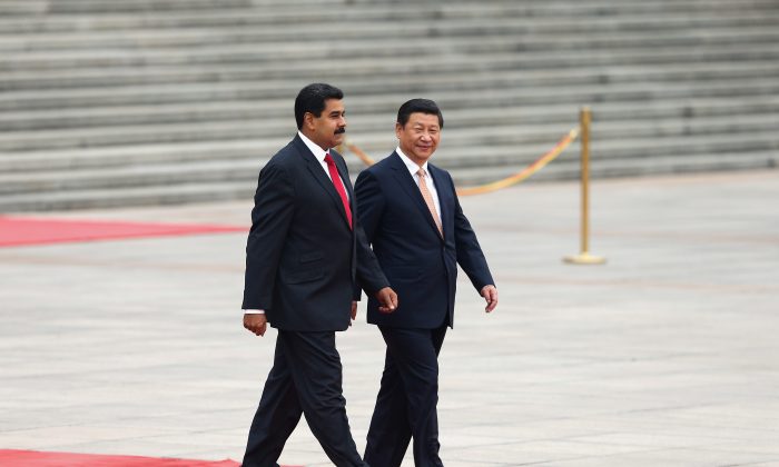 Le dirigeant chinois Xi Jinping (à d.) accompagne le président vénézuélien Nicolas Maduro, lors d'une cérémonie de bienvenue en face du Grand palais du Peuple à Pékin, le 22 septembre 2013. (Lintao Zhang/Getty Images)