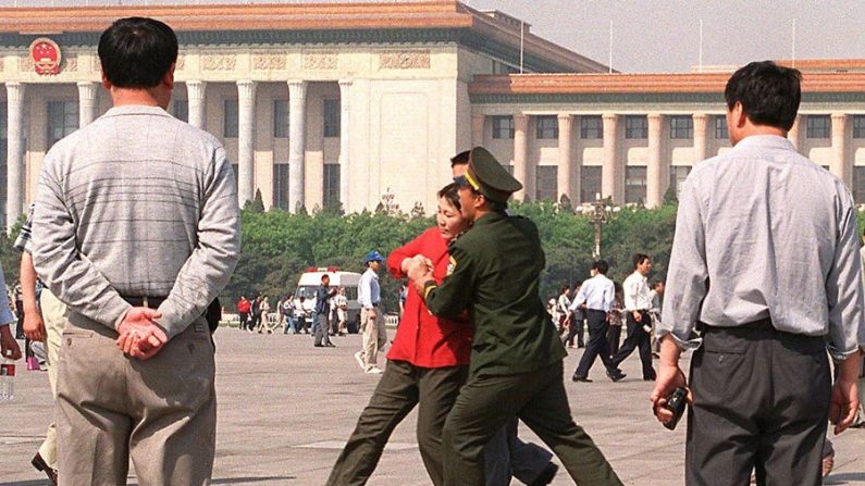 La police arrête des pratiquants de Falun Gong faisant pacifiquement appel à la place Tiananmen, le 11 mai 2000. (Stephen Shaver/AFP/Getty Images)