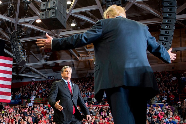 -Le président des États-Unis, Donald Trump, accueille l'animateur d'une émission de débat, Sean Hannity, lors d'un rassemblement à Cape Girardeau, dans le Missouri, le 5 novembre 2018. Photo de Jim WATSON / AFP / Getty Images.