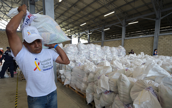 -Un volontaire porte un sac contenant de l'aide humanitaire américaine à Cucuta, en Colombie, le 8 février 2019, à la frontière avec Tachira (Venezuela). Le chef de l'opposition, Juan Guaido, a lancé un défi aux autorités du président Nicolas Maduro. Photo de Raul Arboleda / AFP / Getty Images.