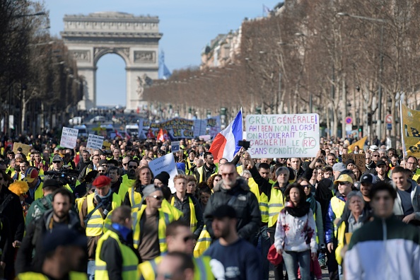 Le 17 février 2019, à Paris, les gens marchent sur l'avenue des Champs-Elysées lors d'une manifestation, appelée par le mouvement des "gilets jaunes", contre la politique du président Emmanuel Macron.  (Photo : ERIC FEFERBERG/AFP/Getty Images)
