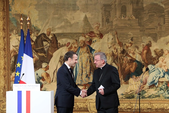 Le Président français Emannuel Macron (à gauche) serre la main au représentant du Pape en France Luigi Ventura, lors de ses vœux de Nouvel An au corps diplomatique le 4 janvier 2018, à l'Elysée à Paris. (LUDOVIC MARIN/AFP/Getty Images)